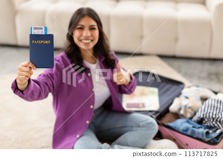 Woman with passport and suitcase at home Woman with passport and suitcase at home 113717825