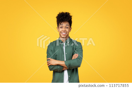 Young man with arms crossed smiling Young man with arms crossed smiling 113717855