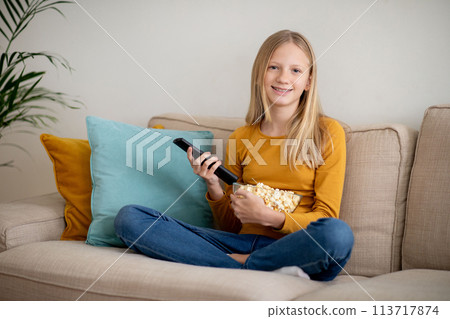 Smiling Teen Girl Watching Television at Home 113717874