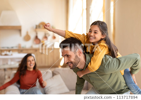Man with daughter on his back and woman smiling 113717894