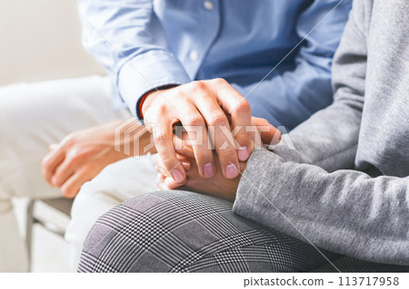 Closeup of unrecognizable man comforting his wife, holding her hands Closeup of unrecognizable man comforting his wife, holding her hands 113717958