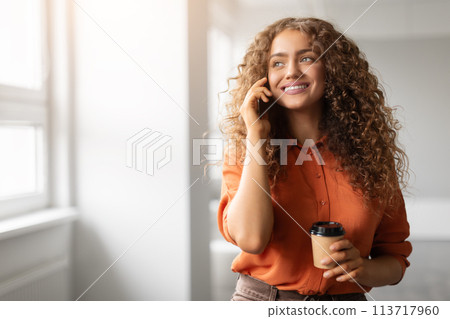 Cheerful woman talking on phone with coffee Cheerful woman talking on phone with coffee 113717960