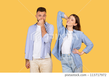 Man covering nose, woman stretching arm Man covering nose, woman stretching arm 113717972