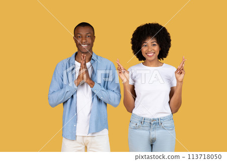Two people with praying hands on yellow 113718050