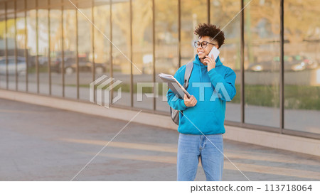 Student walking with a notebook and phone Student walking with a notebook and phone 113718064
