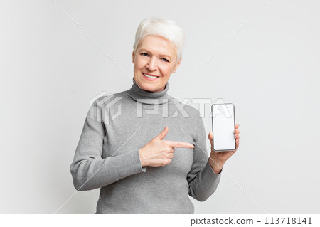 Senior woman pointing at smartphone screen mockup copy space 113718141