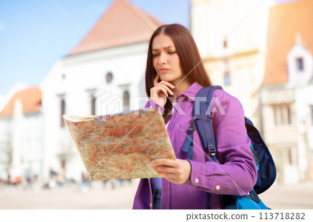 Woman holding map looking confused, copy space 113718282