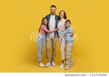 Family portrait with two children smiling on yellow background Family portrait with two children smiling on yellow background 113718288