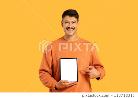 Man holding tablet with blank screen on yellow background Man holding tablet with blank screen on yellow background 113718315
