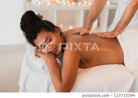 Woman enjoying a back massage at a spa Woman enjoying a back massage at a spa 113718394