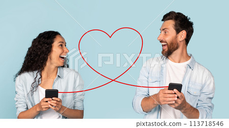 A laughing woman in a light blue shirt and a man in a denim jacket smile while looking at each other 113718546