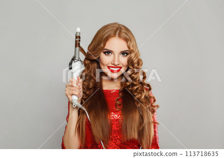 Beautiful young glamorous woman with long straight and curly hair holding curling iron Beautiful young glamorous woman with long straight and curly hair holding curling iron 113718635