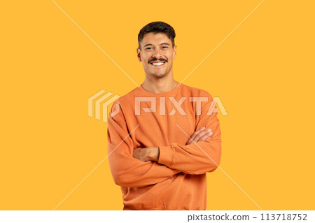 Smiling man with arms crossed on yellow 113718752