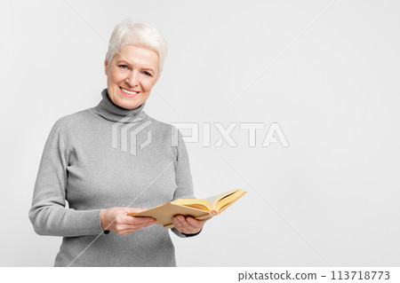 Seniors' joy of reading a book on grey background Seniors' joy of reading a book on grey background 113718773