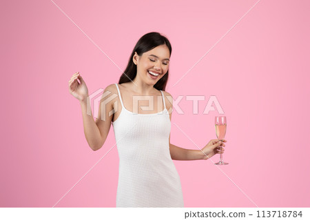 Young lady holding a champagne flute cheerfully Young lady holding a champagne flute cheerfully 113718784