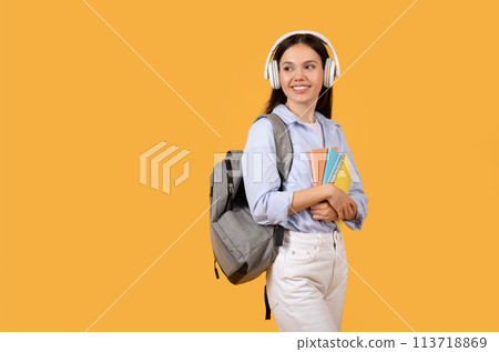 Student with headphones and backpack on yellow 113718869