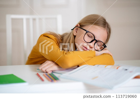 Young Girl Reading Book at Table 113719060