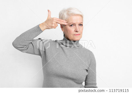 Senior lady signaling a gun to the head 113719115