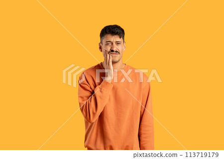 Man with toothache on orange studio background 113719179