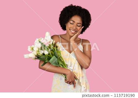 Woman holding flowers with a joyful expression 113719190
