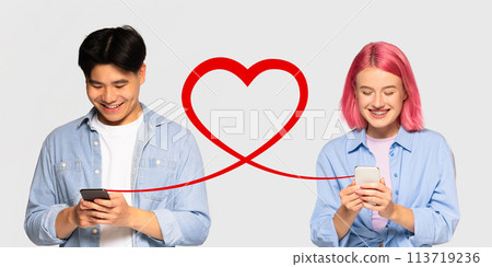 A young man in a denim shirt and a woman with pink hair, both smiling at their phones 113719236