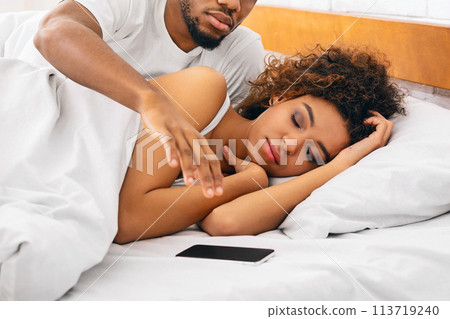 Black man grabbing phone while his woman sleeping Black man grabbing phone while his woman sleeping 113719240