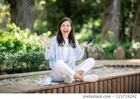 An exuberant young woman in light attire expresses joy and surprise with a wide smile An exuberant young woman in light attire expresses joy and surprise with a wide smile 113719242