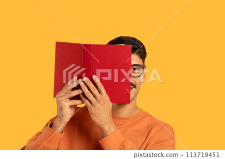 Man with moustache covering face with a book Man with moustache covering face with a book 113719451