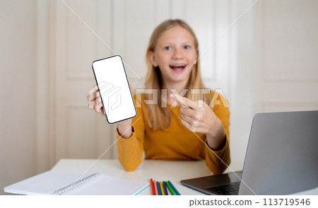 Excited Teen Girl Showing Blank Smartphone Screen While Study At Home Excited Teen Girl Showing Blank Smartphone Screen While Study At Home 113719546