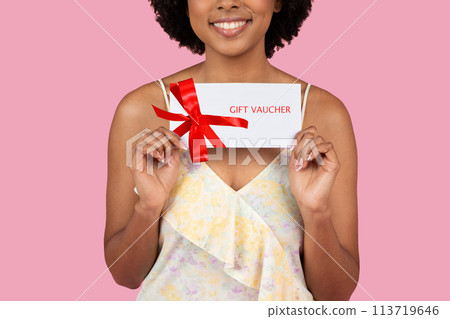 Woman with floral dress holding a gift voucher Woman with floral dress holding a gift voucher 113719646