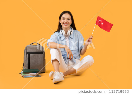 Casual woman holding Turkish flag on yellow background 113719953