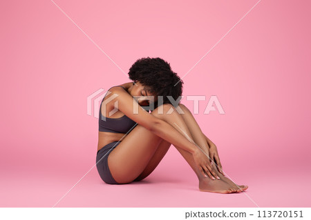 Fitness woman touching her legs on pink background Fitness woman touching her legs on pink background 113720151
