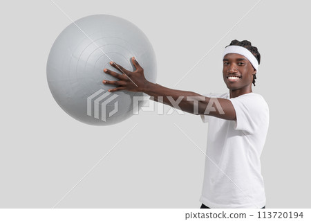 Athletic man posing with exercise ball on white background Athletic man posing with exercise ball on white background 113720194