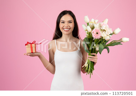 Woman presenting flowers and gift box on pink background 113720501