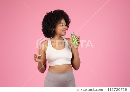 Woman enjoying a sip of green juice Woman enjoying a sip of green juice 113720756