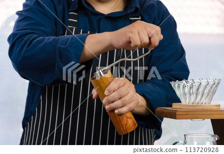 Coffee drip maker. Barista grounding coffee beans. 113720928