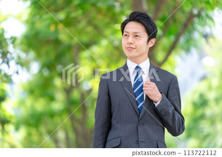 Businessman walking through the fresh greenery Businessman walking through the fresh greenery 113722112