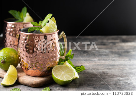 Moscow mule cocktail served with ice and lime slice on wooden table Moscow mule cocktail served with ice and lime slice on wooden table 113723828