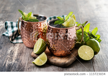 Moscow mule cocktail served with ice and lime slice on wooden table Moscow mule cocktail served with ice and lime slice on wooden table 113723834
