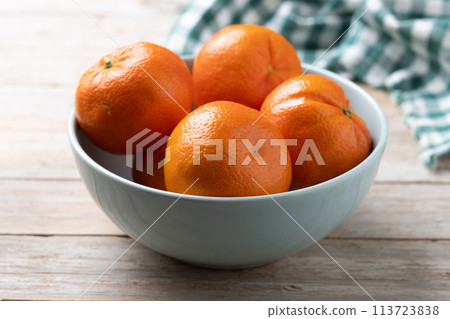 Fresh tangerines in bowl on wooden table Fresh tangerines in bowl on wooden table 113723838