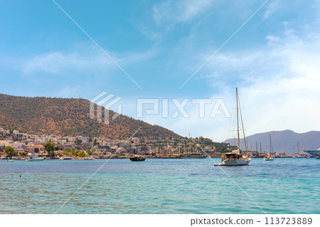 Sailboat in the sea over mountains and seaside resort town background. 113723889