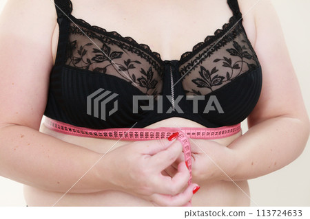 Woman measuring her chest under breasts Woman measuring her chest under breasts 113724633