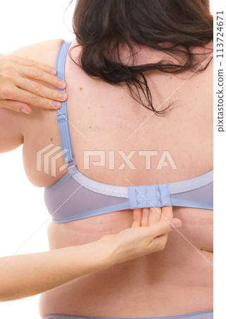 Bra fitter help plus size woman find perfect fit. Back view. Bra fitter help plus size woman find perfect fit. Back view. 113724671