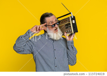 Happy old man listen music on retro tape record player, disco dancing, fan of vintage technologies 113724819