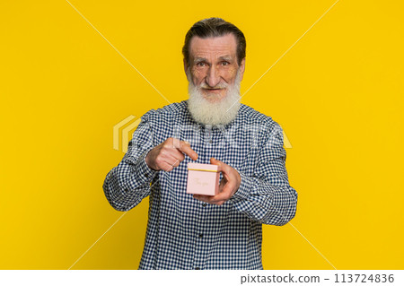 Smiling senior man presenting jewelry gift present box stretches out hands, promotion discount sale Smiling senior man presenting jewelry gift present box stretches out hands, promotion discount sale 113724836