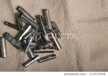 Used finger batteries on a beige dirty background. Recycling of waste. 113725048