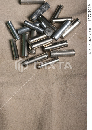 Used finger batteries on a beige dirty background. Recycling of waste. 113725049
