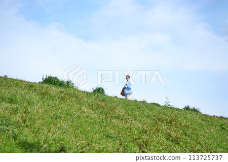 A woman walking the bank A woman walking the bank 113725737