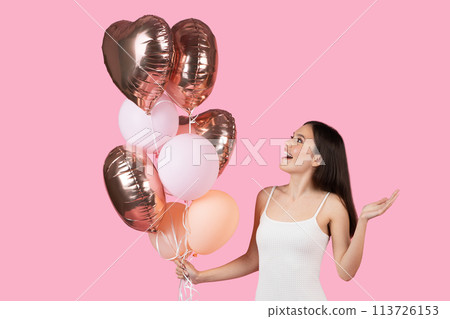 Lady gestures with heart-shaped balloons on pink background Lady gestures with heart-shaped balloons on pink background 113726153
