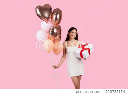 Lady in white dress with balloons and gift 113726154